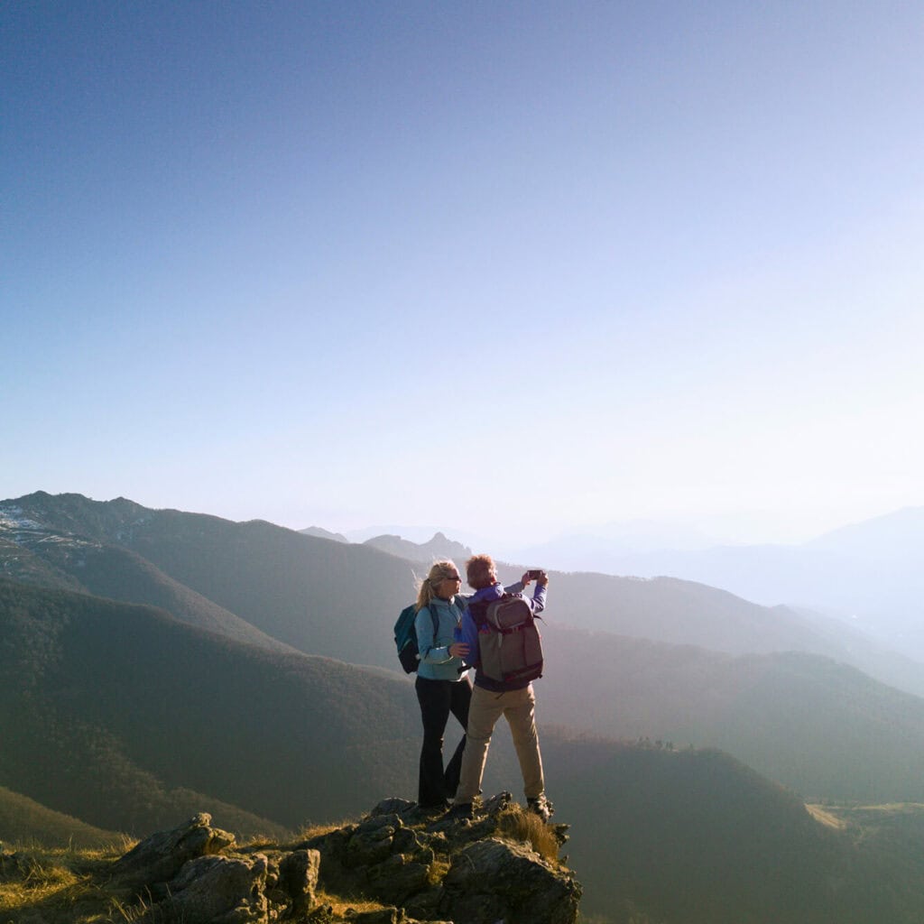 Zwei Wanderer mit Blick über das Tal – AVACOMM bringt Glasfaser auch in abgelegene Regionen und Randgebiete für zukunftssichere Konnektivität von Glasfaserverbindungen.