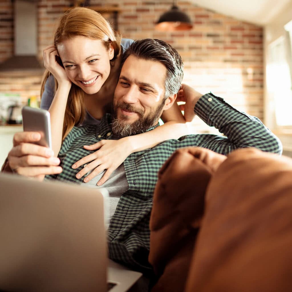 Glasfaser bis in die Wohnung FTTH, glückliches Paar streamt Inhalte mit stabilem Glasfaser-Internet von AVACOMM