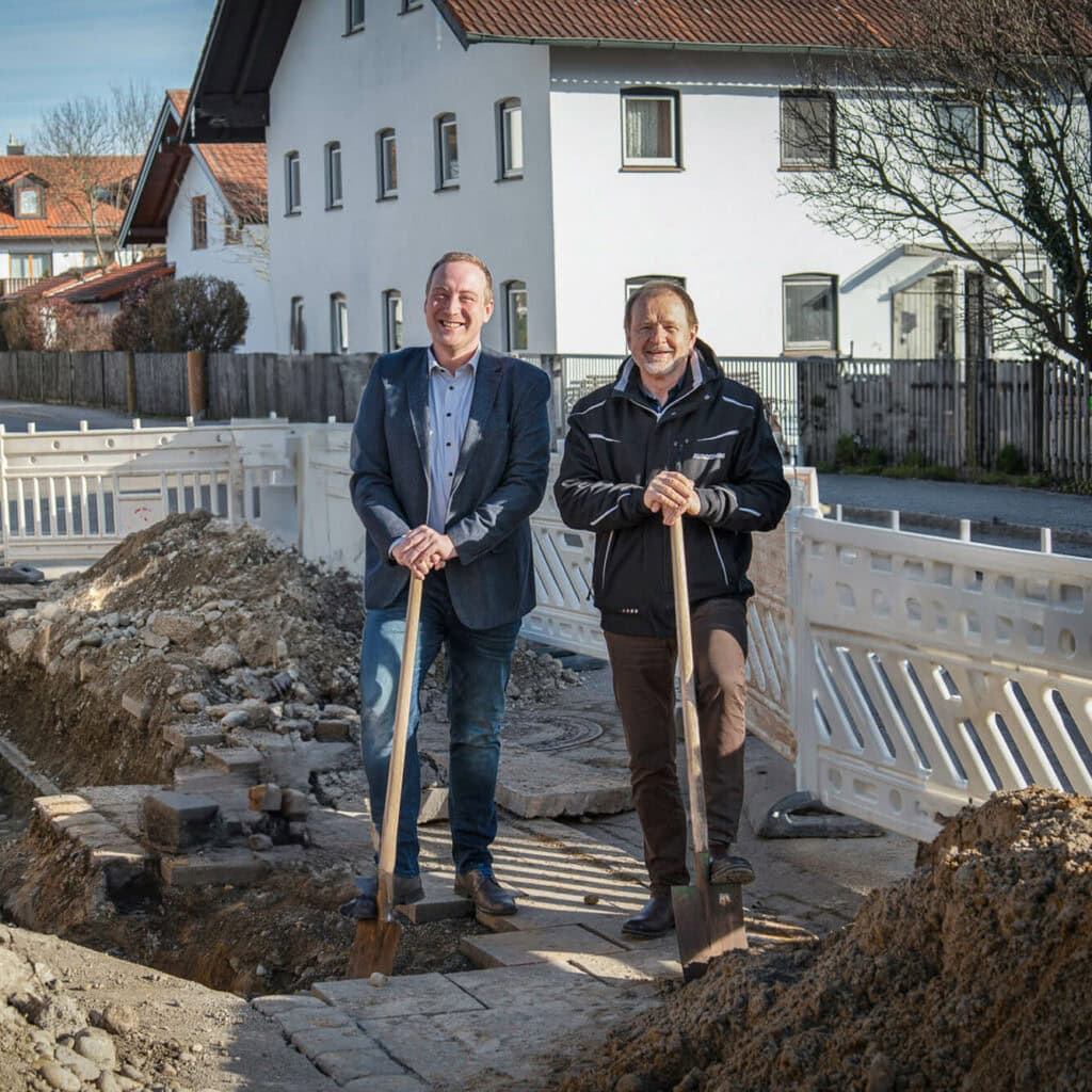 Zwei Männer beim Spatenstich für den Glasfaserausbau in Vaterstetten – Startschuss für die digitale Zukunft.