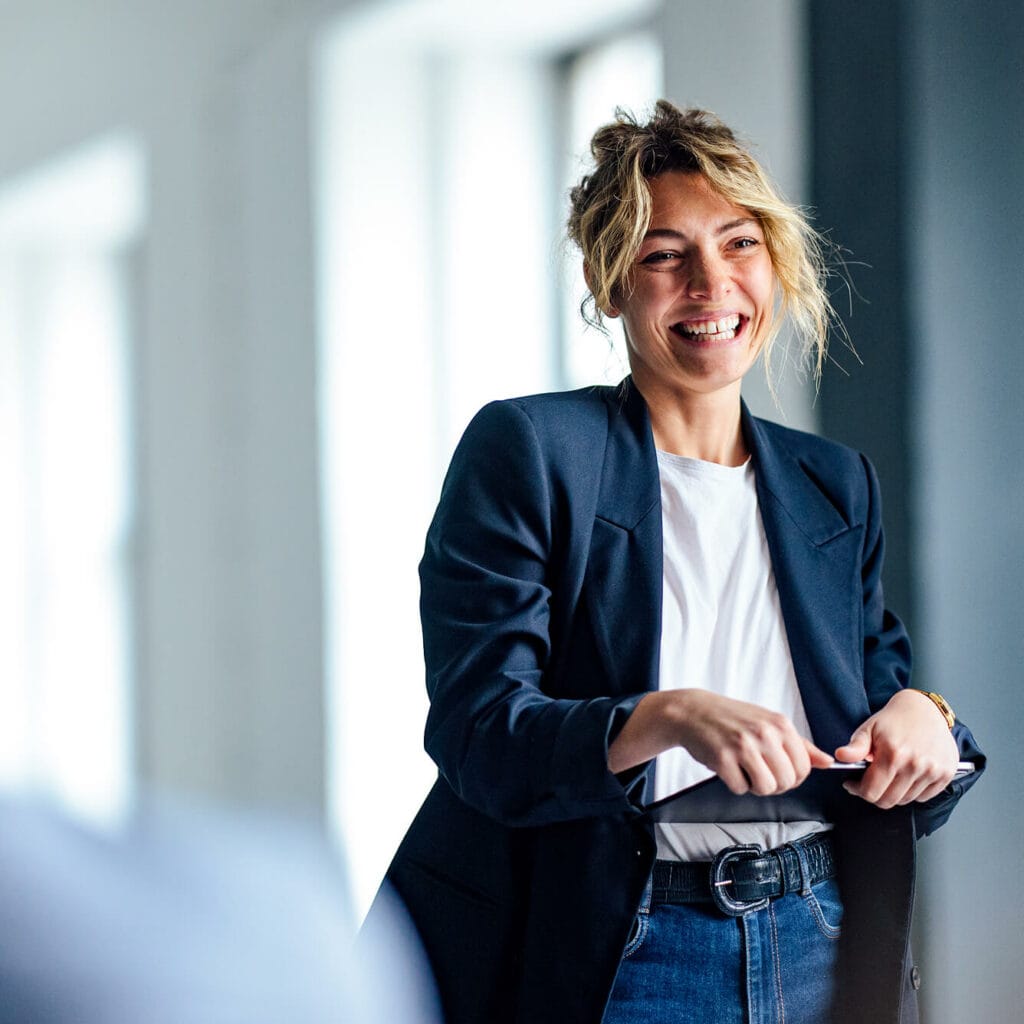 Geschäftsfrau lächelt im Gespräch – digitale Lösungen und Glasfasertechnologie für Hausverwaltungen mit AVACOMM