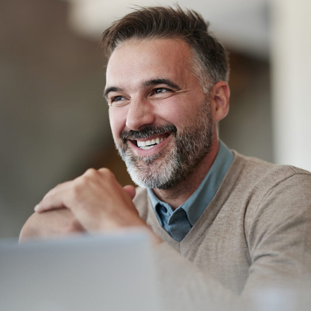 CEO, vor einem Laptop sitzend, freut sich über stabile und schnelle Glasfaserverbindung von Avacomm